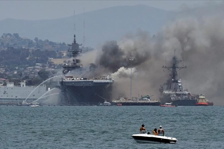 Firefighting boats spray water onto the U.S. Navy amphibious assault ship USS Bonhomme Richard as smoke rises from a fire onboard the ship at Naval Base San Diego, as seen from Coronado, California. REUTERS/Bing Guan    